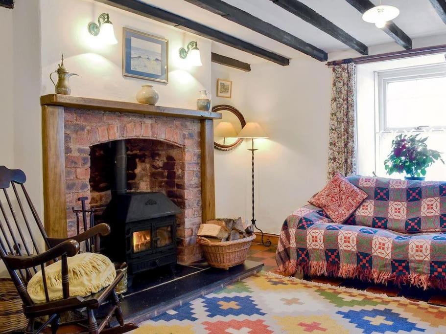 a living room with a fireplace and a couch at Gerlan (no. 4, Station Rd) in Tregaron