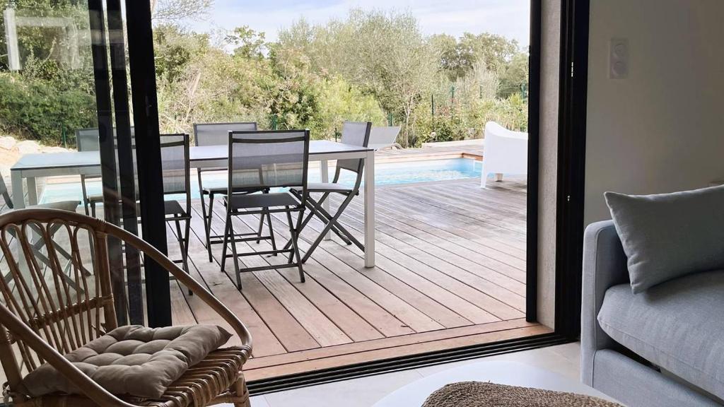un patio avec une table et des chaises sur une terrasse dans l'établissement Villa Copines, 4 pers, piscine chauffée, 5 mn plage, à Cirendinu
