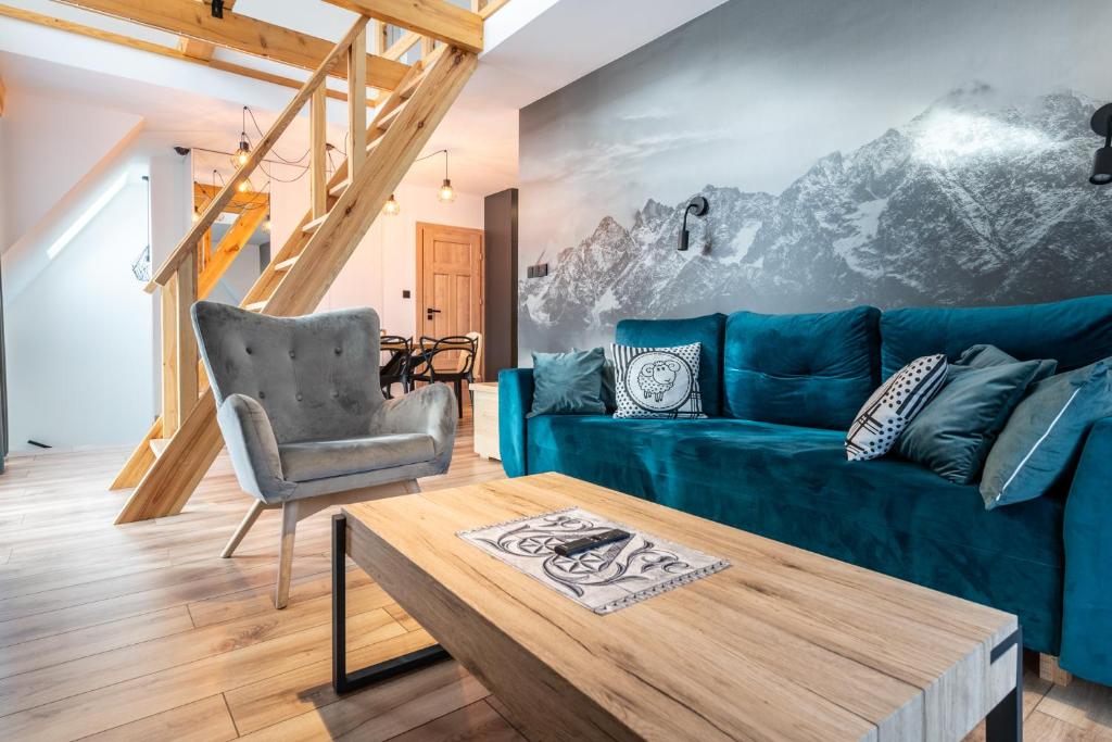ein Wohnzimmer mit einem blauen Sofa und einem Tisch in der Unterkunft Czarny Baran in Zakopane