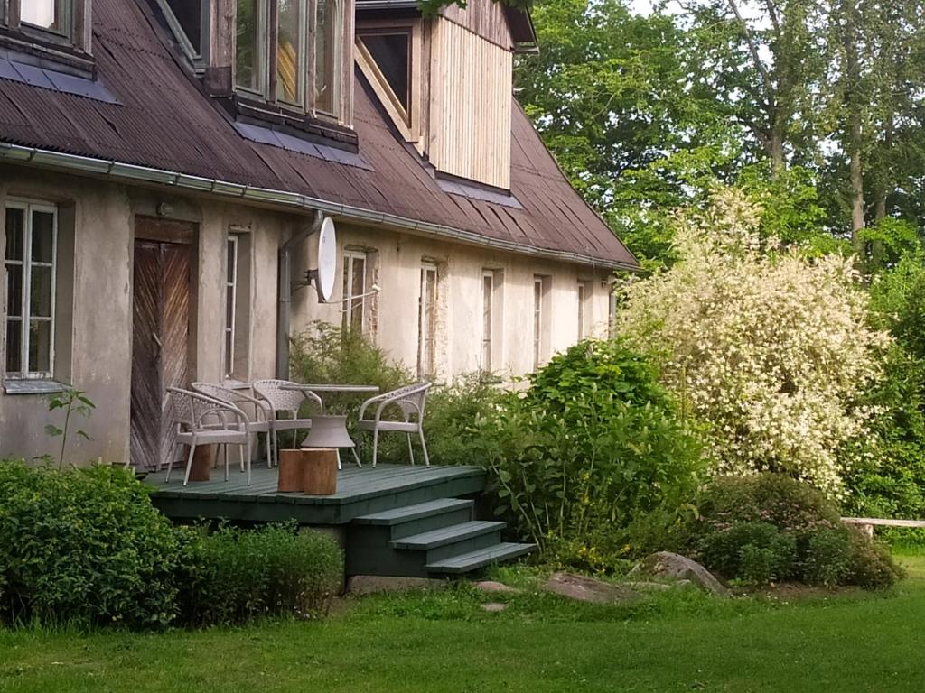 una casa con una mesa y sillas en un porche en Guest House Ružciems, en Lamiņi