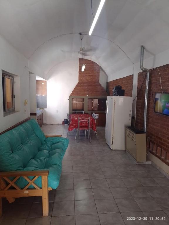 uma sala de estar com um sofá verde e uma cozinha em emili em Las Grutas