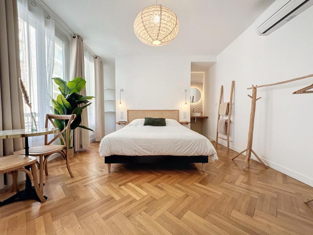 um quarto com uma cama e piso em madeira em - - Maison ŪMA - Marseille - - Wifi, Mer et Centre em Marselha