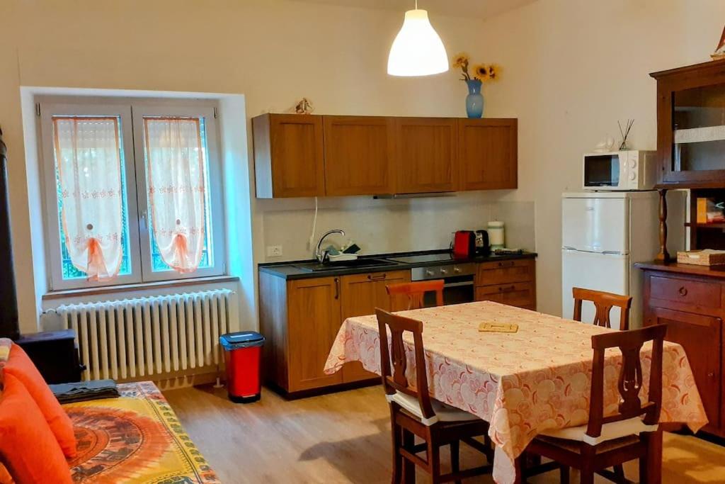 cocina con mesa con sillas y cocina con nevera en Casa Vitiolo - parte sinistra, 