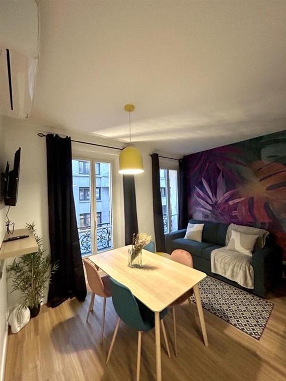 un salon avec une table et un canapé dans l'établissement Appartement cosy - Quartier Saint-Georges - 4P, à Paris