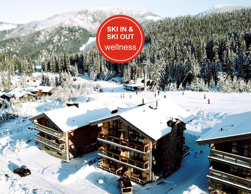 a ski resort in the snow with a sign that says ski in and ski out at ChaletSKI Jasná, SKI-IN & SKI-OUT in Demanovska Dolina