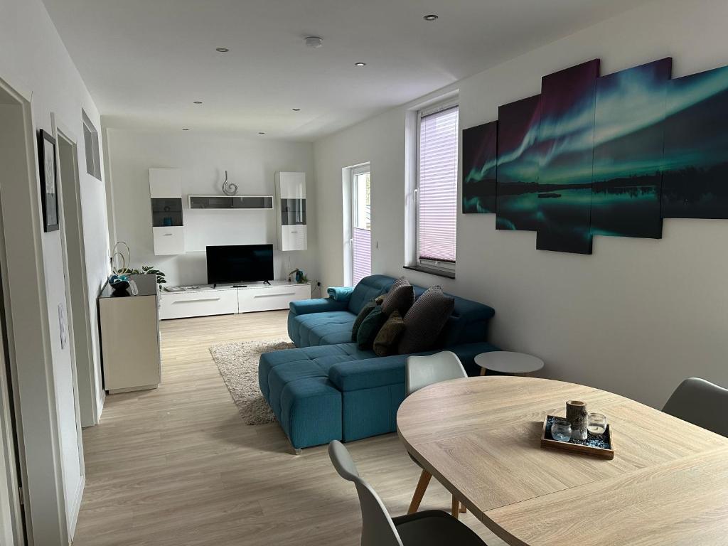 een woonkamer met een blauwe bank en een tafel bij Apartment Zentral in Willingen