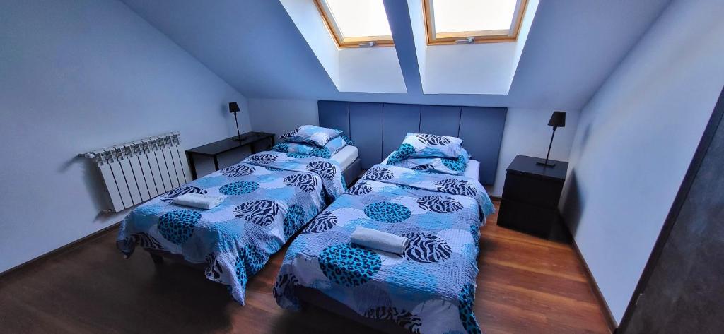 2 łóżka w małym pokoju z 2 oknami w obiekcie M Hostel w mieście Gliwice