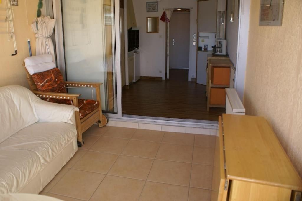 un salon avec un canapé et une table et une cuisine dans l'établissement Studio 16, Héliopolis FGH au village naturiste, au Cap d'Agde