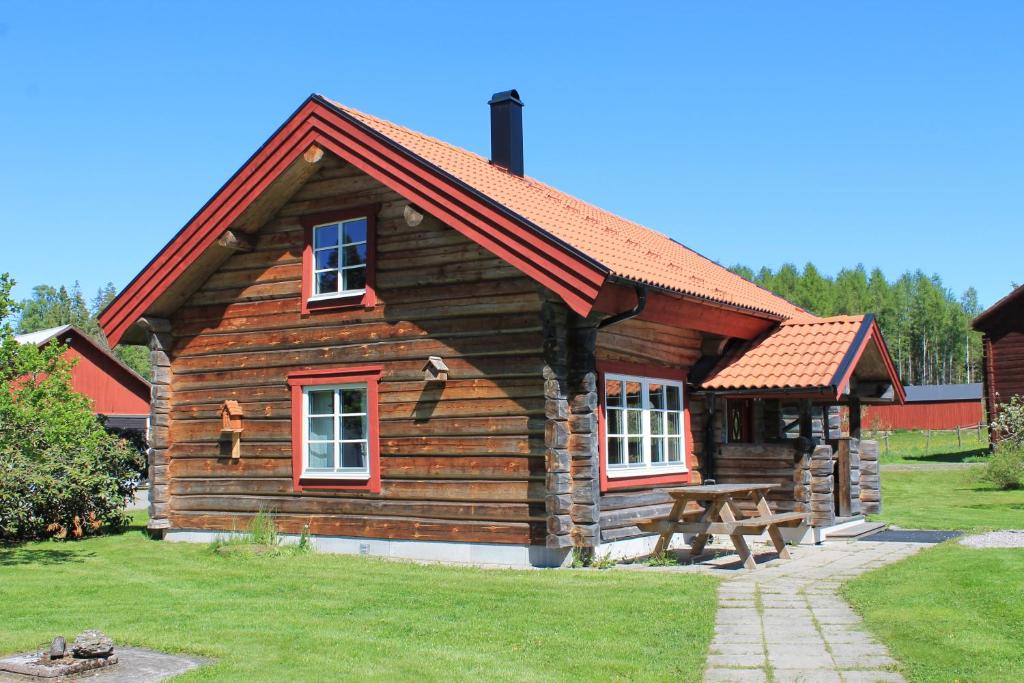 una cabaña de madera con una mesa de picnic delante de ella en Fårgården Åsebol, en Gårdsjö