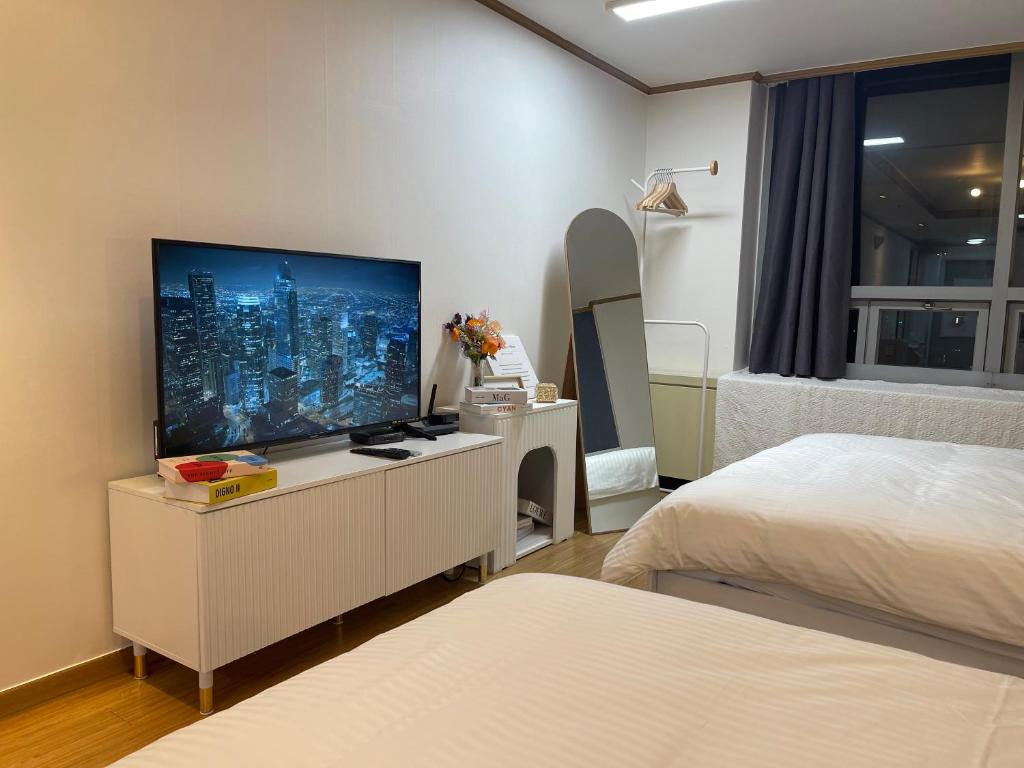 a bedroom with a flat screen tv on a dresser at Serein_HongDae in Seoul