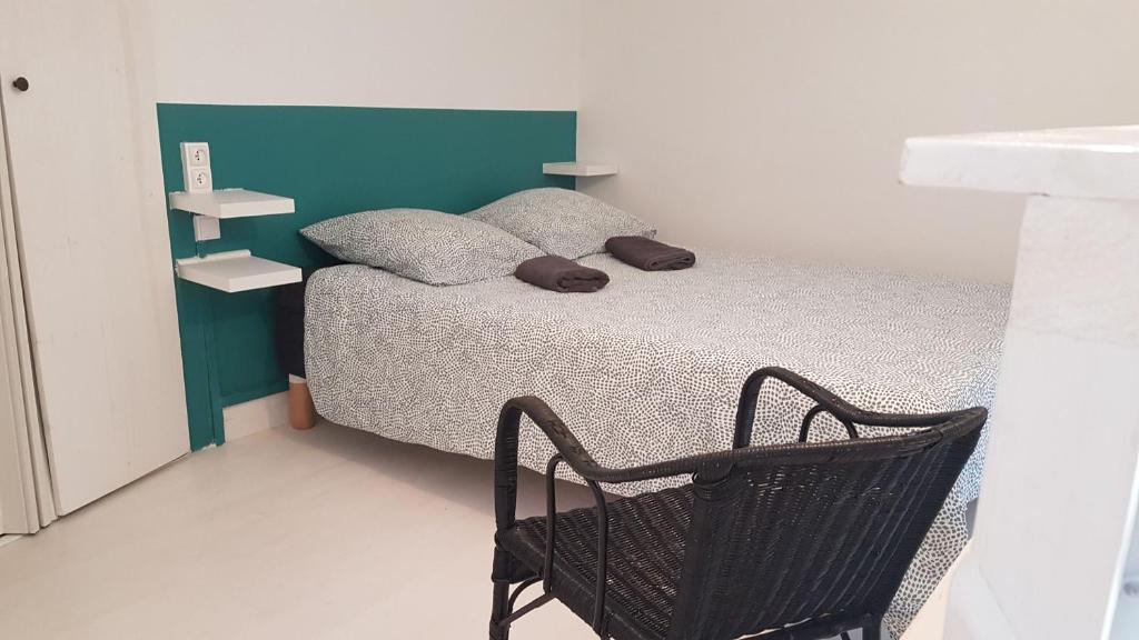 1 dormitorio pequeño con 1 cama y 1 silla en Chambre cosy dans petit loft en París