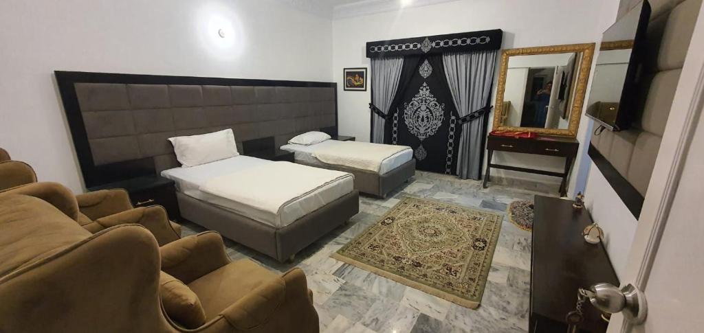- un salon avec un lit, un canapé et un miroir dans l'établissement Shelton House, à Karachi
