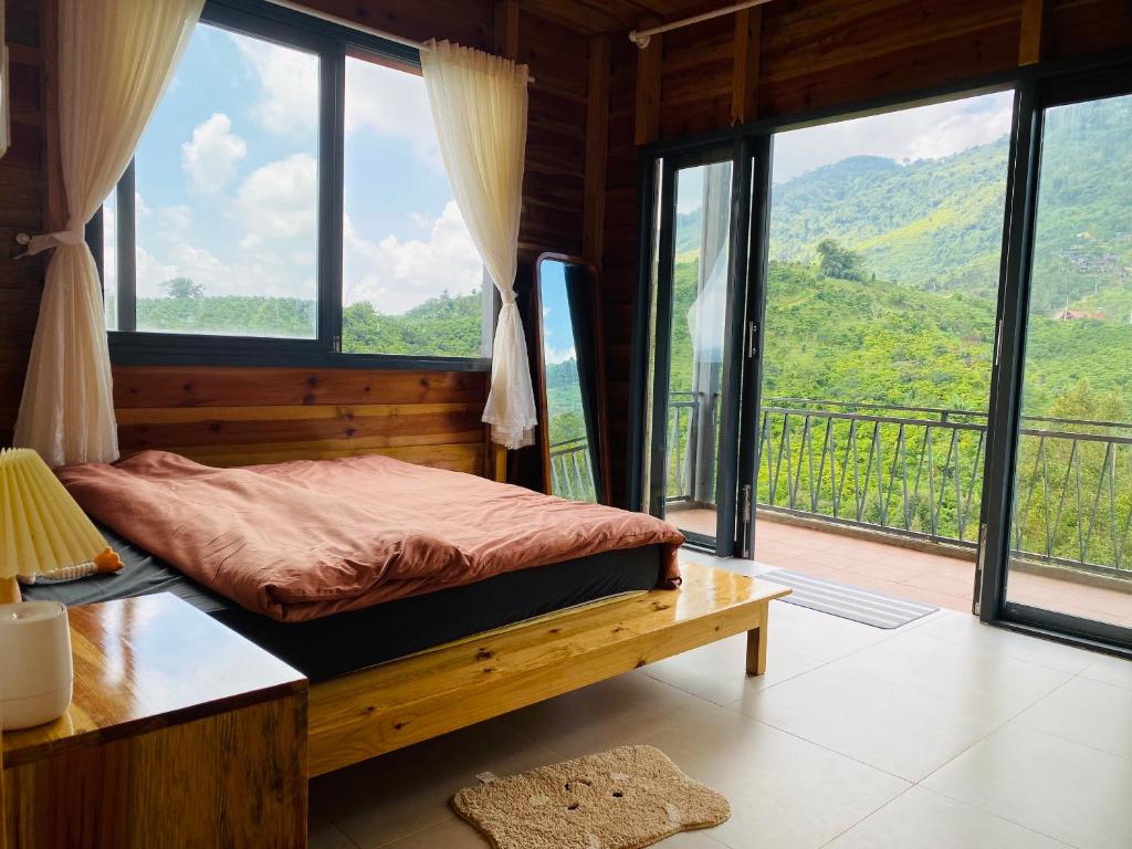 a bedroom with a bed with a view of a mountain at Lam Nguyên Farm Stay in Bao Loc