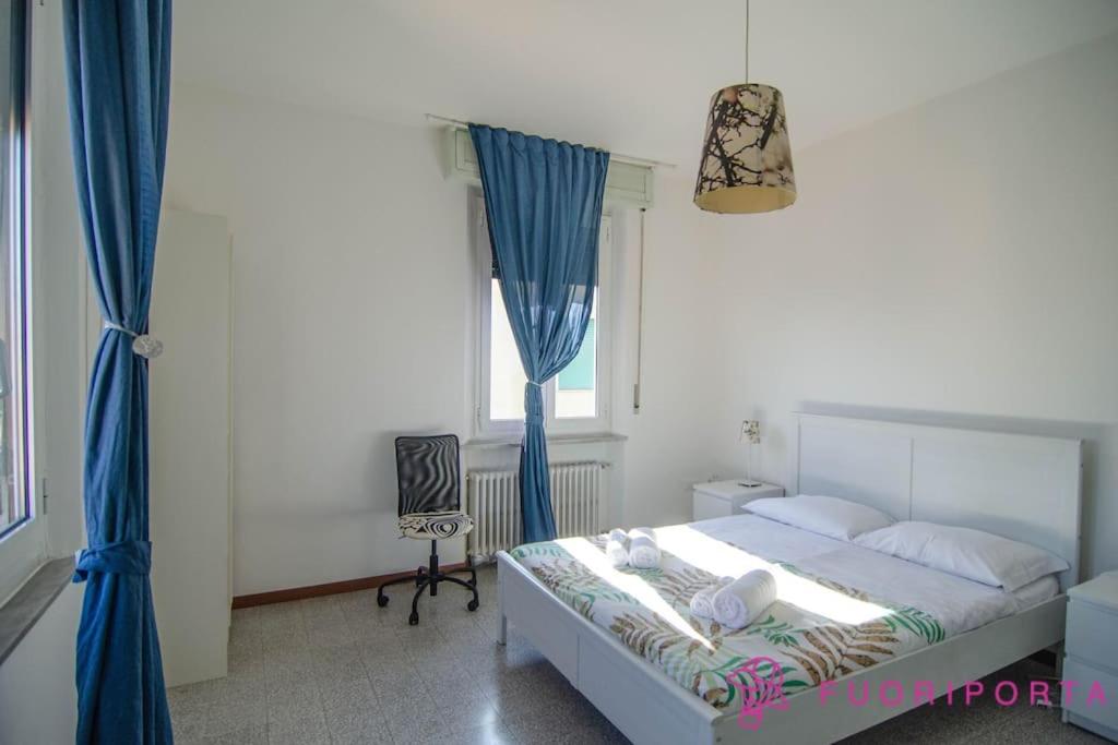 um quarto com uma cama com cortinas azuis e uma janela em Borgo San Giuseppe 16 em Parma