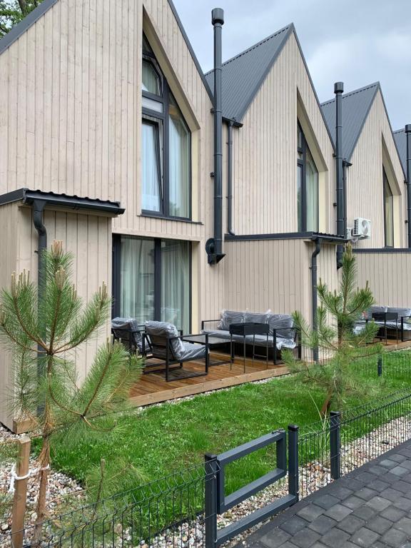 ein Haus mit einer Holzterrasse davor in der Unterkunft Geriausios Atostogos in Palanga