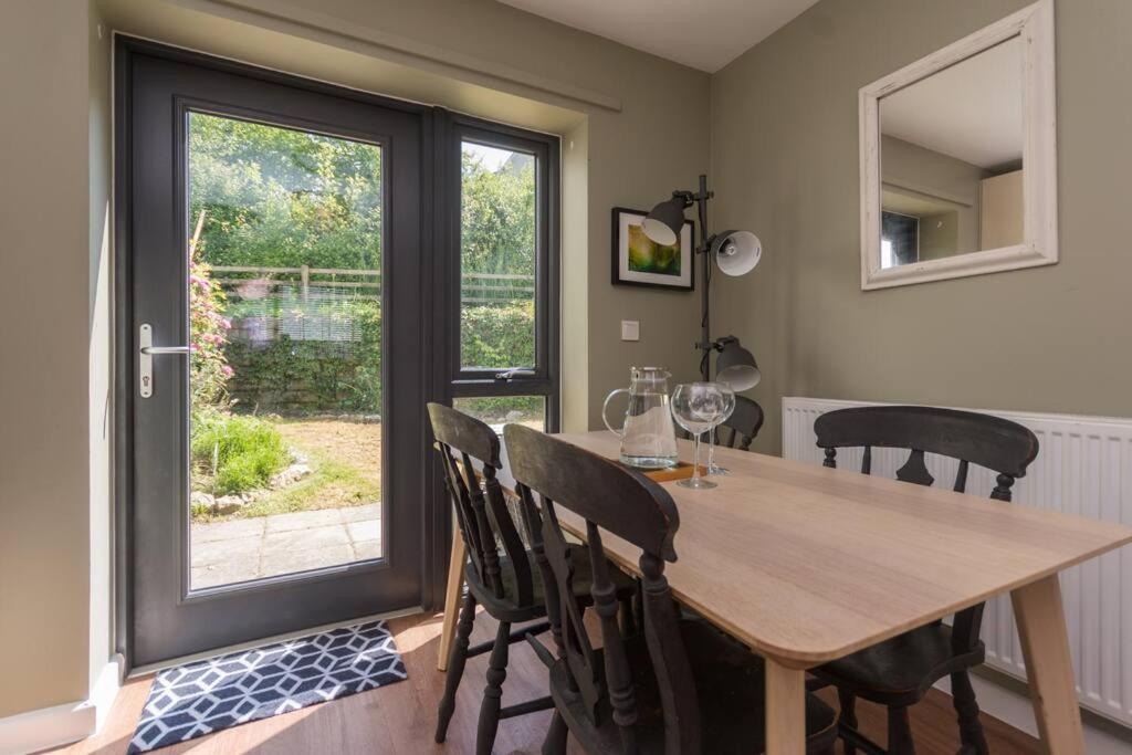 a dining room with a table and chairs and a window at Convenient Totnes Town Centre Family Home with Parking 2 bedrooms in Dean