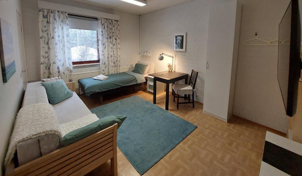 a room with two beds and a table and a desk at Wera in Porvoo
