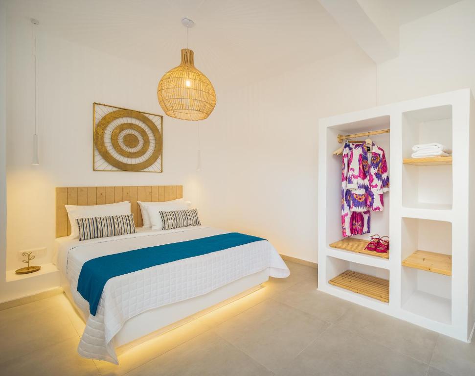 Dormitorio blanco con cama y estante en SELANA Suites Chora, en Serifos Chora