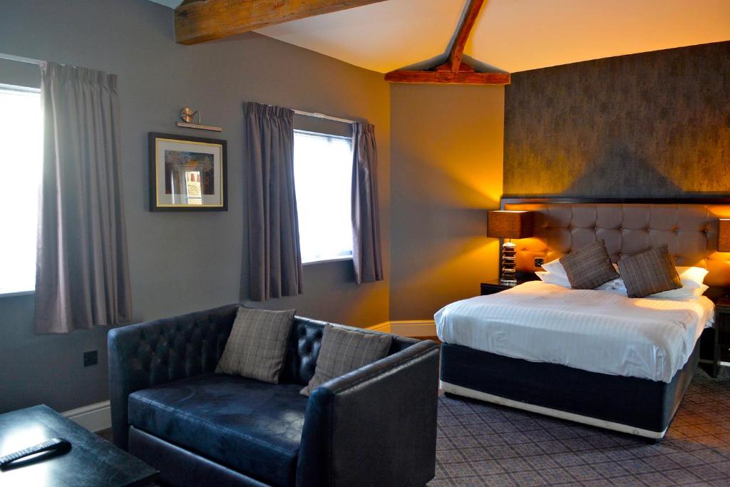 um quarto de hotel com uma cama e um sofá em The Angel Hotel Wetherspoon em Whitby