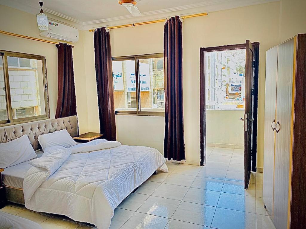 a bedroom with a large bed and a window at Huwari Apartments in Aqaba