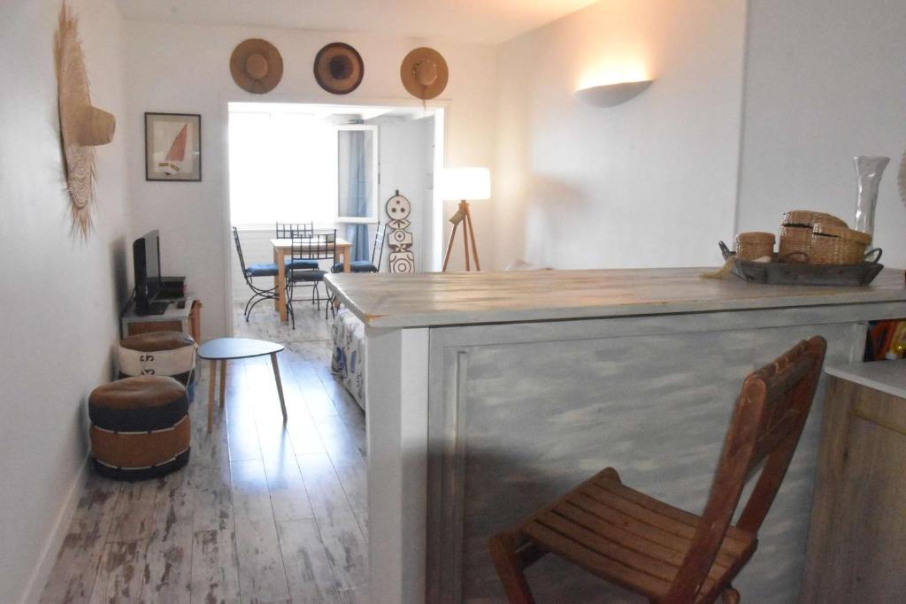 une cuisine avec un bar, une chaise et une table dans l'établissement Face à la plage, climatisation, WiFi, parking, tout à pied, idéal vacances, à Six-Fours-les-Plages