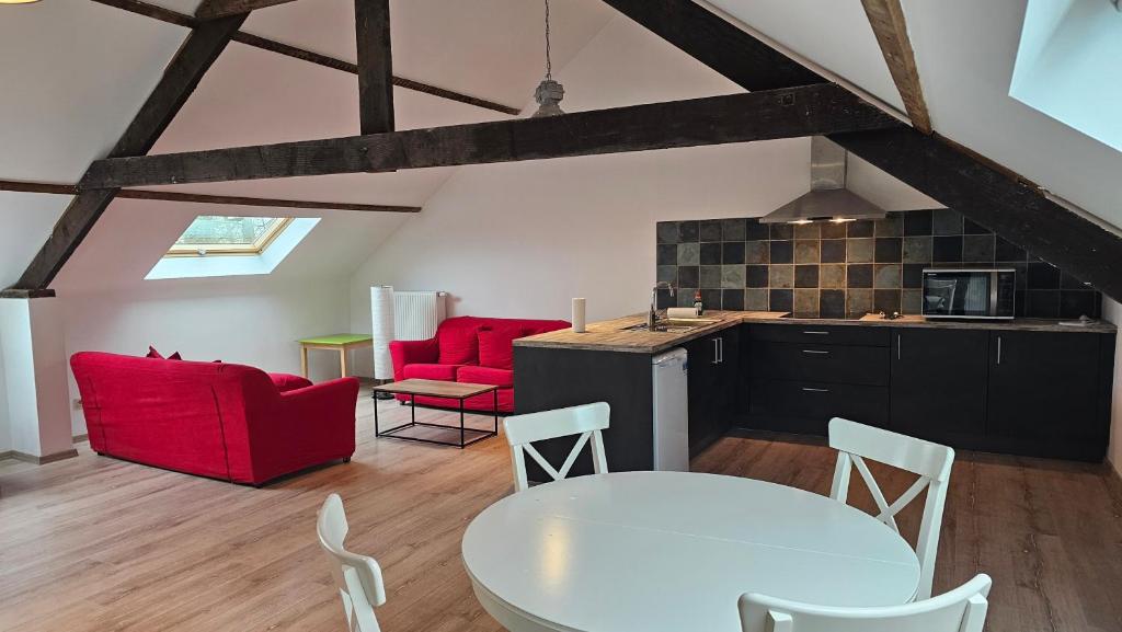 een keuken en een woonkamer met rode stoelen en een tafel bij Casa Kakelbos in Rotselaar