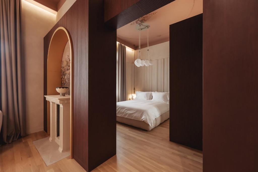 a hotel room with a bed and a hallway at Zenith Premium Suites in Thessaloniki