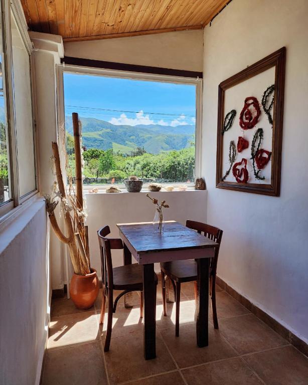 a table and chairs in a room with a window at Casa Feito Tafi in Tafí del Valle