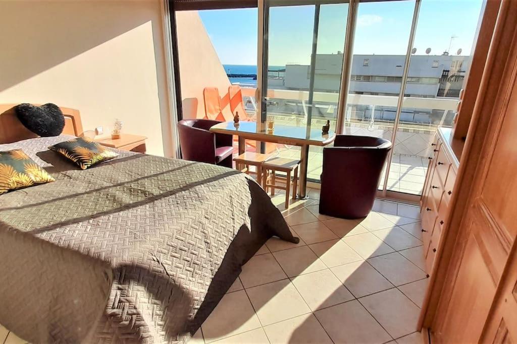 une chambre avec un lit et une vue sur l'océan dans l'établissement Studio 4, Héliopolis D au village naturiste, au Cap d'Agde