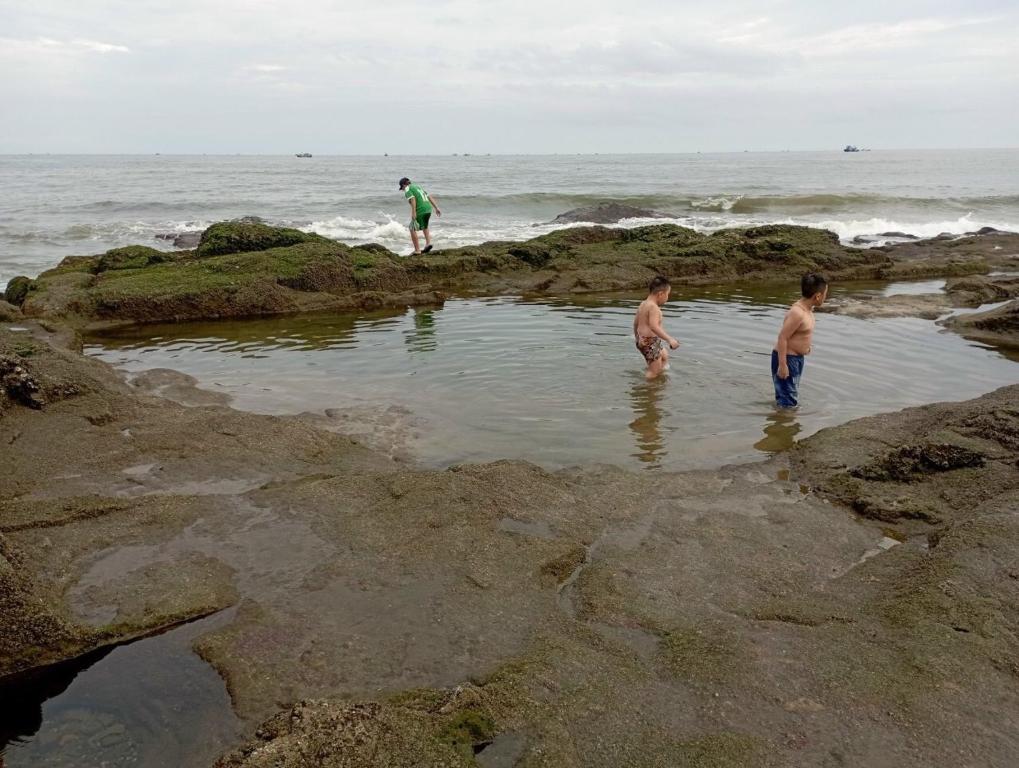 Tre ragazzi che giocano in una piscina d'acqua sulla spiaggia di Sun Moon Home 3 a Phan Thiet