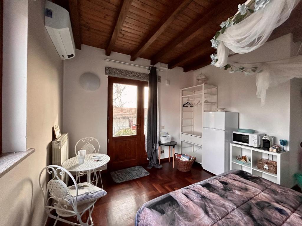 1 dormitorio con 1 cama, mesa y nevera en In campagna, en Besozzo