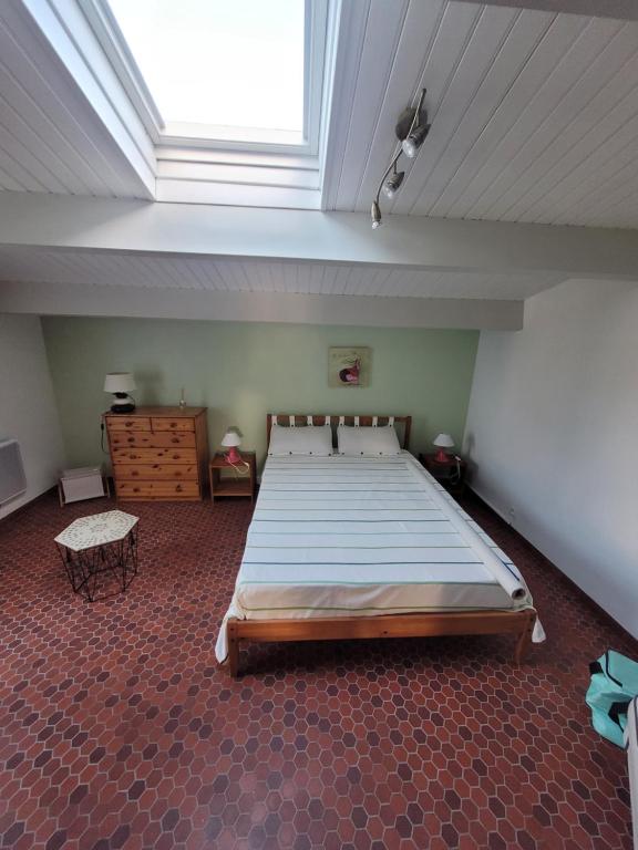 - une grande chambre avec un grand lit et une lucarne dans l'établissement Dolce Vita, à Notre-Dame-de-Monts