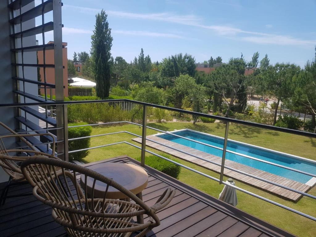 balcón con silla y piscina en Pool Beach & Golf Troia Reserve V3 en Grândola