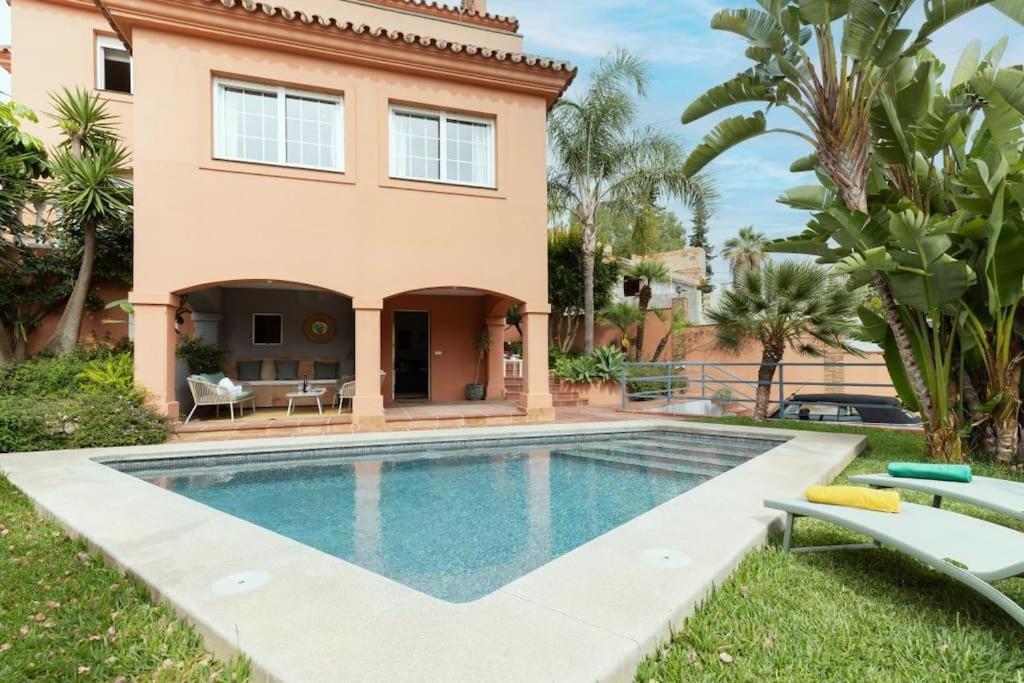 a villa with a swimming pool in front of a house at Traditional Spanish villa near Puerto Banus in Marbella