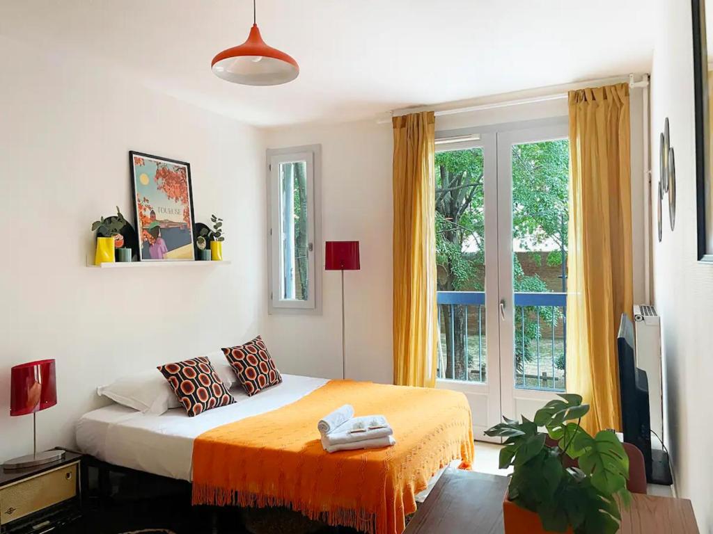 - une chambre avec un lit et une couverture orange dans l'établissement Groovy by Yumē, à Toulouse