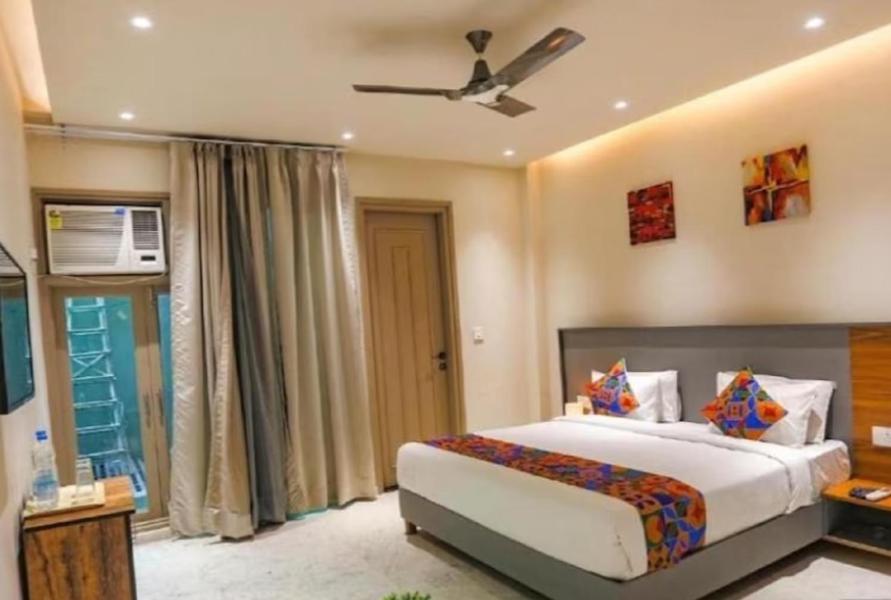 um quarto com uma cama e uma ventoinha de tecto em HOTEL GLOBAL CORPORATE NOIDA em Noida