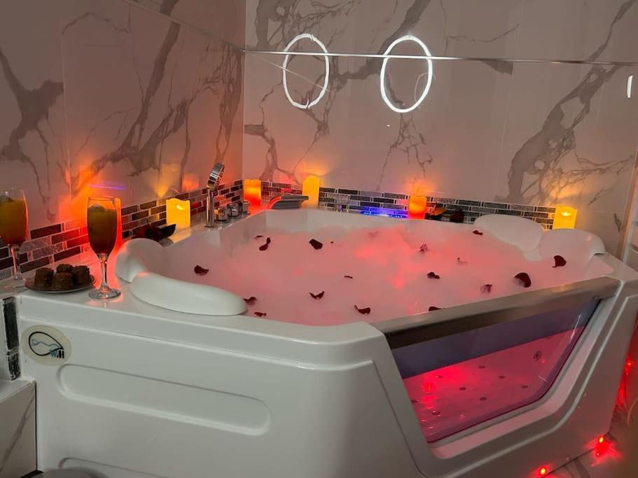 a bathroom with a tub with a wine glass at Luxueux Appartement Jacuzzi proche de Paris in La Celle-Saint-Cloud