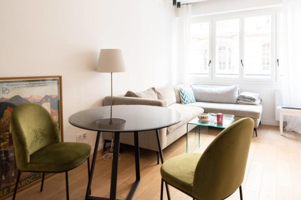 a living room with a couch and a table and chairs at Beautiful Apartment Near The Eiffel Tower in Paris