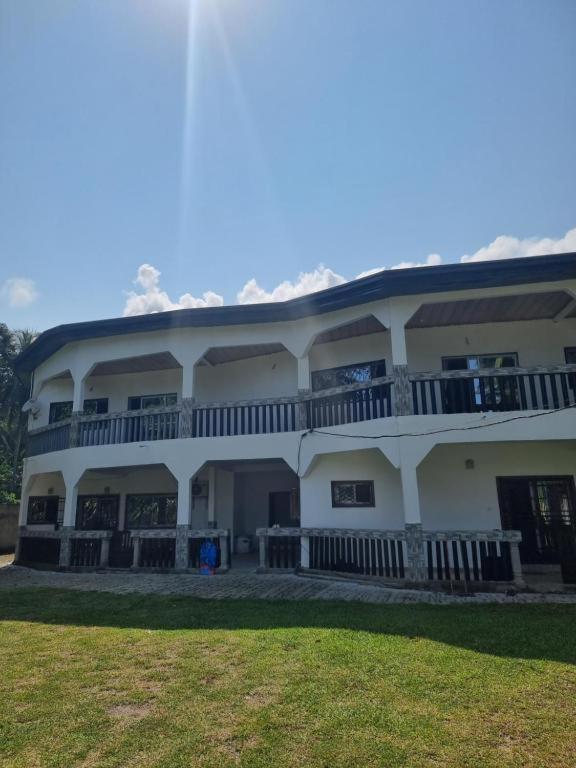 a large white building with a porch and balcony at LES VAGUES BLEUES in Ilendé