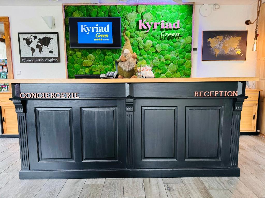 eine Bar in einem Laden mit einem Schild an der Wand in der Unterkunft Kyriad Lisieux in Lisieux