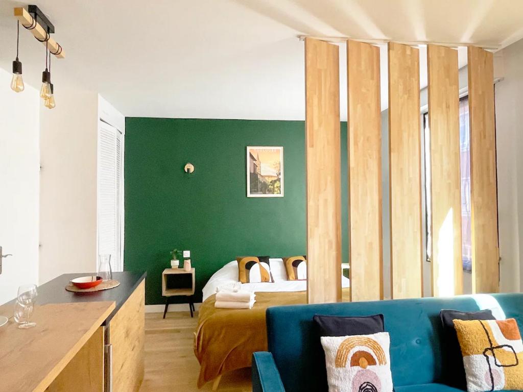 - un salon avec un lit et un canapé bleu dans l'établissement Péri by Yumē, à Toulouse
