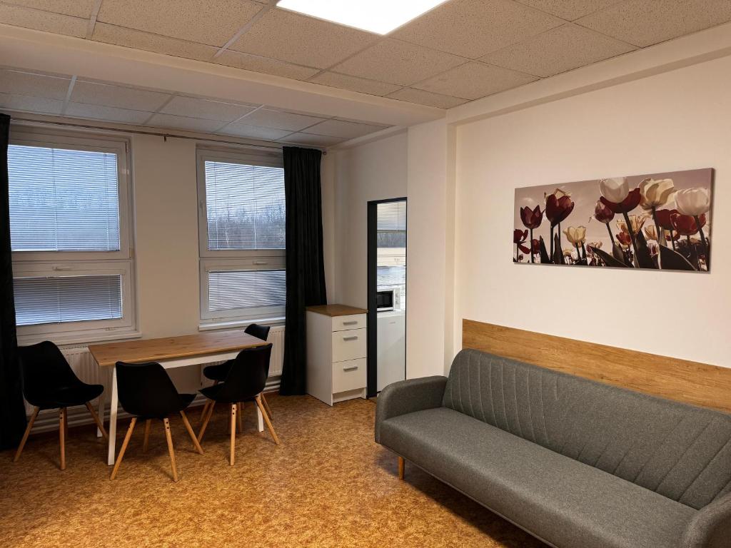 a waiting room with a couch and a table and chairs at D8 APARTMÁNY in Ústí nad Labem