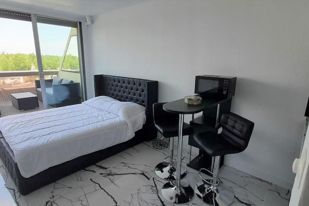 une chambre avec un lit, une table et des chaises dans l'établissement Studio 43, Héliopolis L au village naturiste, au Cap d'Agde
