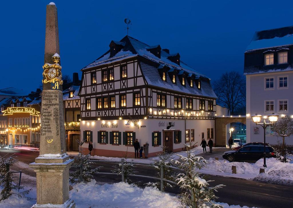 a building with a clock on the side of it in the snow at Hotel Roß in Zwönitz