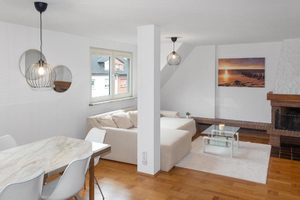 a living room with a white couch and a table at Skyview Retreat Maisonette in Essen