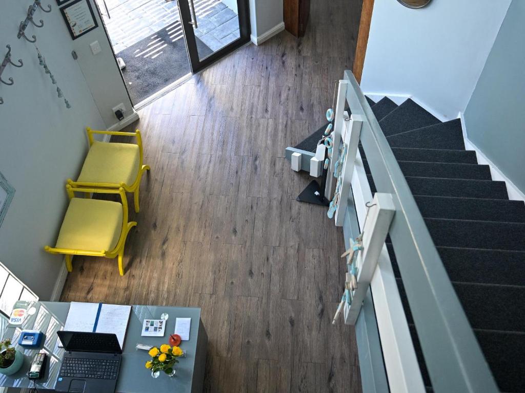 uma vista superior de um escritório com uma mesa e cadeiras amarelas em Atlantic Oasis Guest House em Table View
