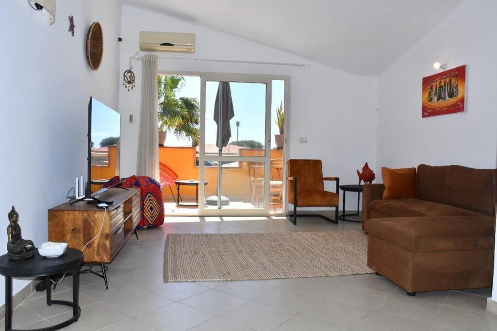 a living room with a couch and a table at Kyaala Djadsal Moradias pool&sea in Santa Maria