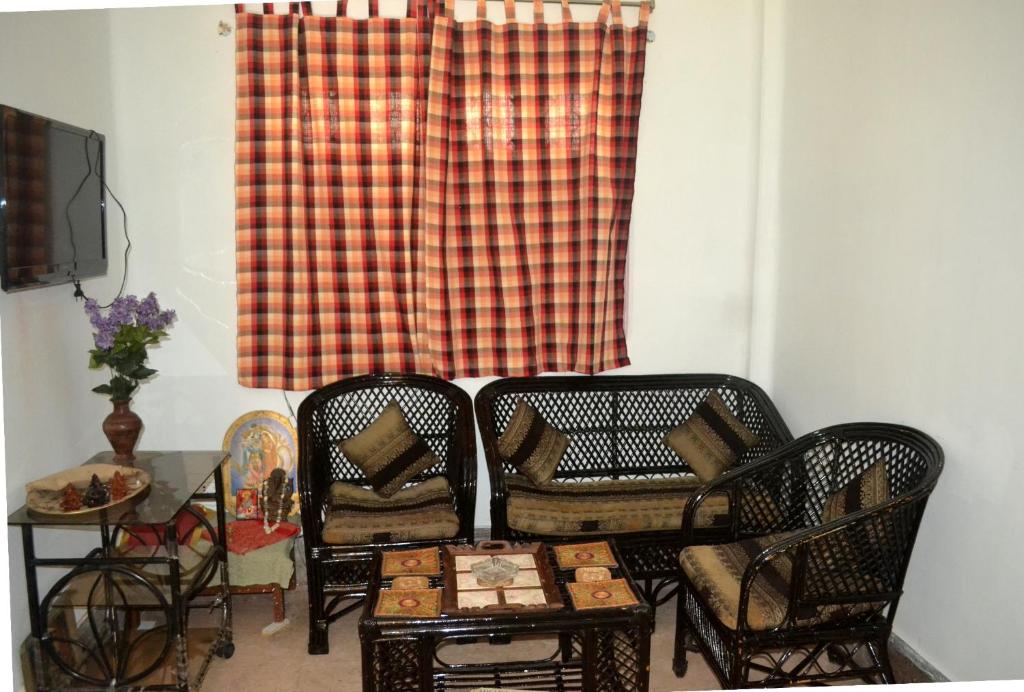 twee stoelen en een tafel voor een raam bij Gayitri in Calcutta
