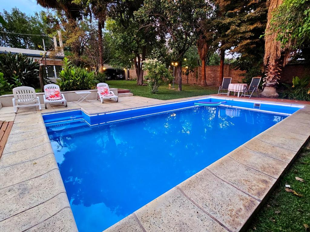 einen blauen Pool mit Stühlen und eine Terrasse in der Unterkunft Casa del Buen Viaje in Mendoza