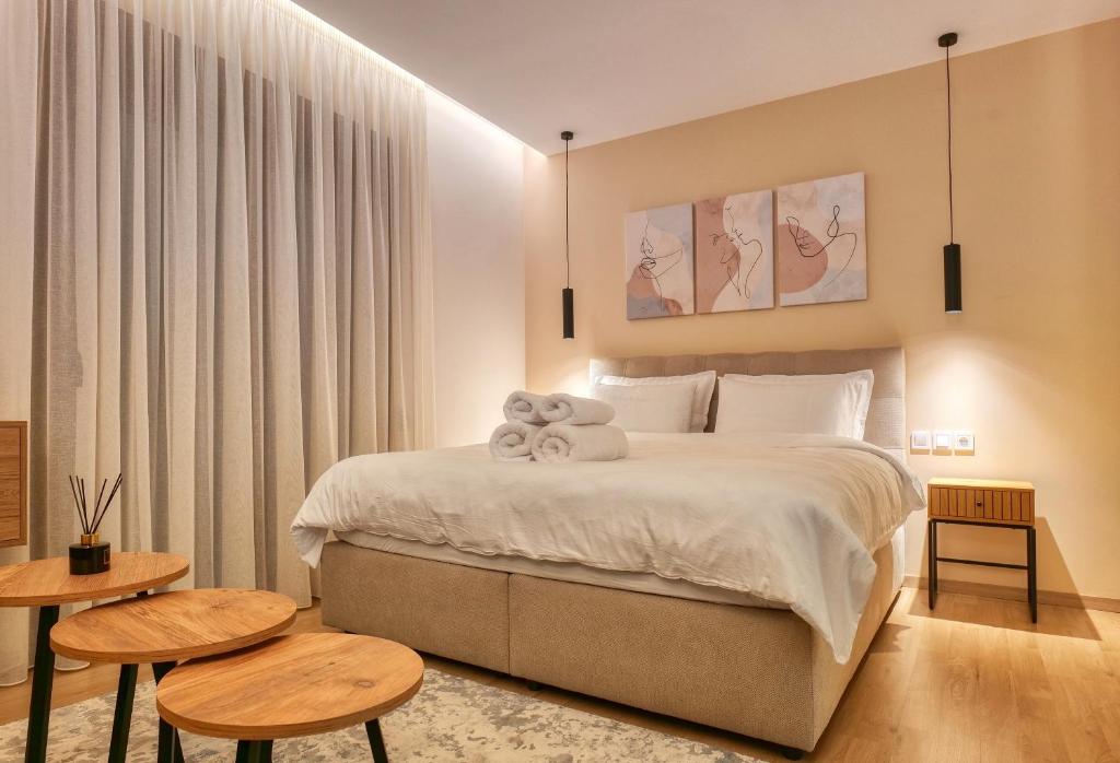 1 dormitorio con 1 cama grande y 2 mesas en Harmony Center Luxury Apartment, en Komotiní